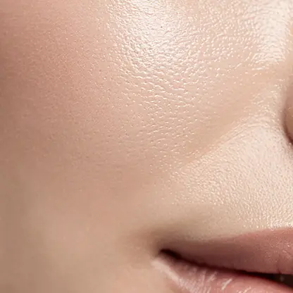 Close-up of glowing healthy skin with soft natural curls of light and shadow, minimal background, clean beauty aesthetic, calm luxury vibe, macro editorial photography, high resolution
